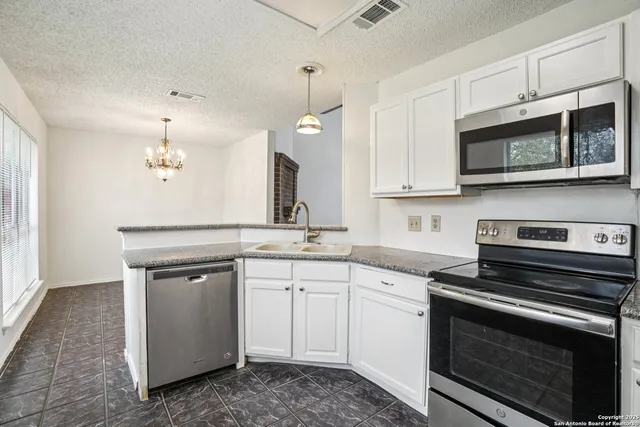 a kitchen with stainless steel appliances granite countertop a stove and a sink