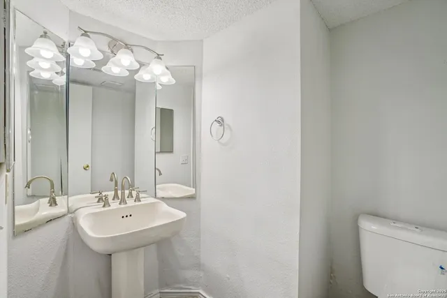 a bathroom with a sink mirror and toilet