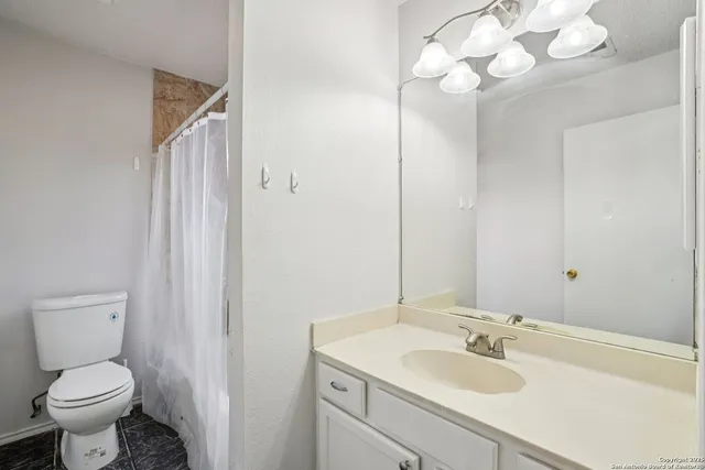 an empty room with a window and a ceiling fan