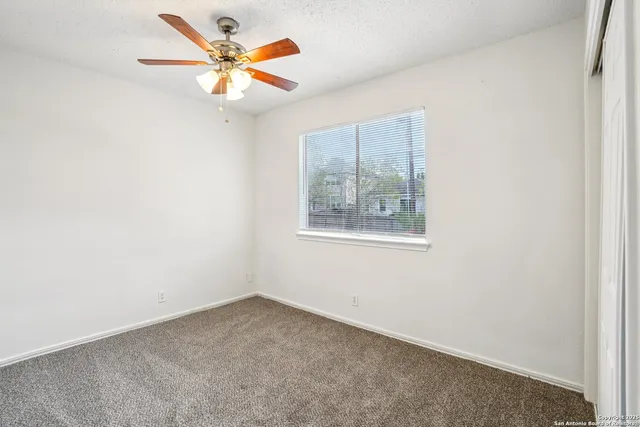 an empty room with a fan and a fan