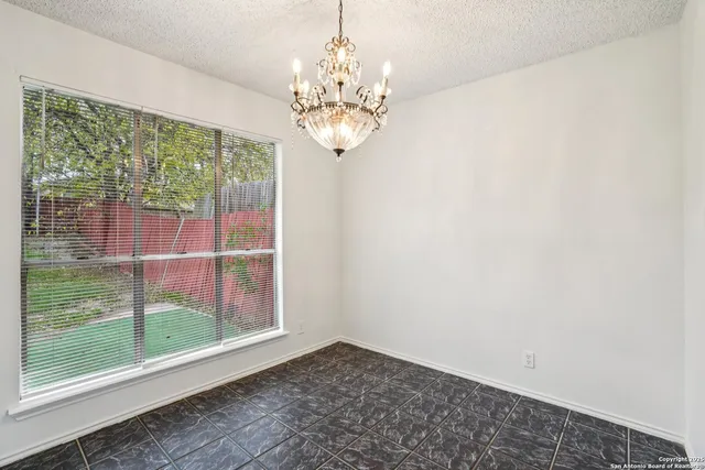 a view of a chandelier in big room with wooden floor