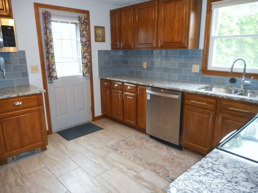 2 Poe Road Billerica, MA 01821 - Photo 9 of 34 a kitchen with stainless steel appliances granite countertop a sink stove and cabinets