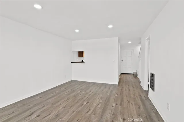 a view of a big room with wooden floor and windows