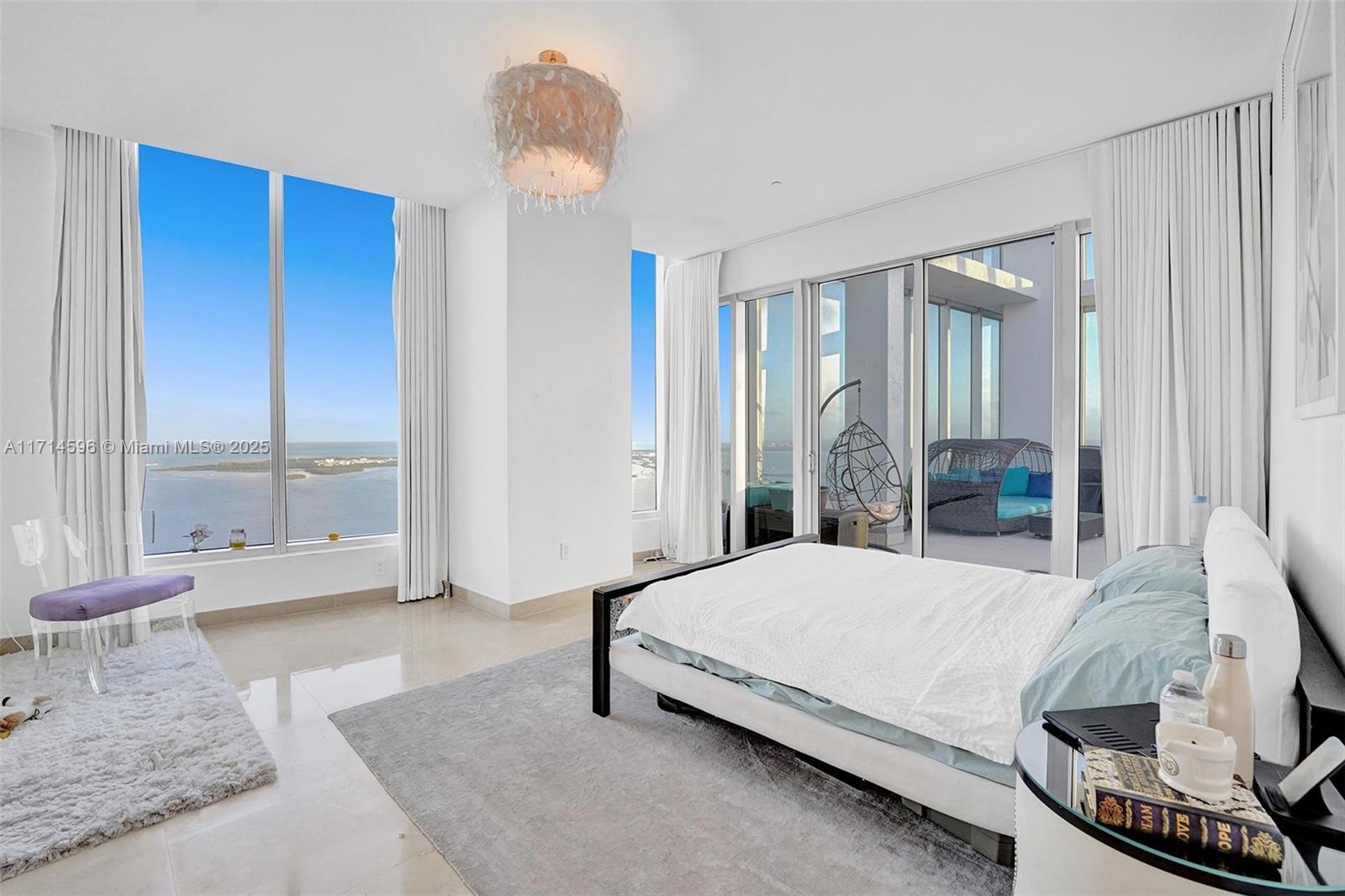 495 Brickell Avenue, Unit PH5701 Miami, FL 33131 - Photo 18 of 31 a bedroom with a bed and large windows