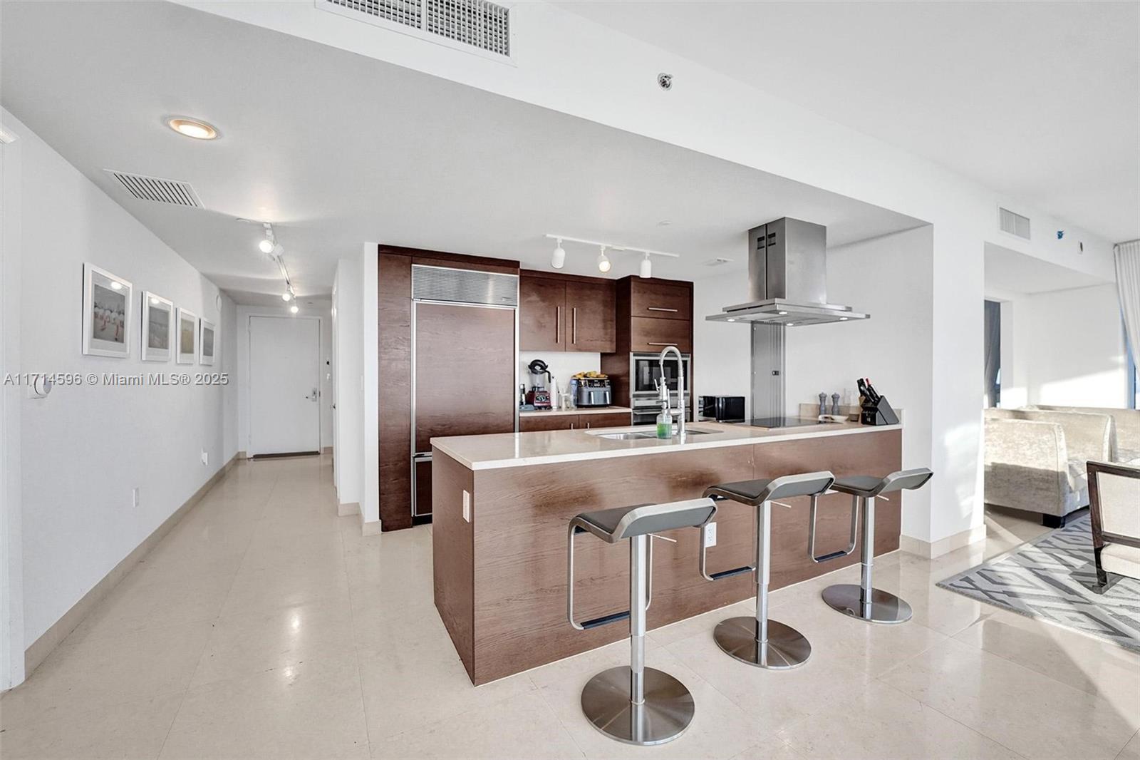 495 Brickell Avenue, Unit PH5701 Miami, FL 33131 - Photo 4 of 31 a kitchen with cabinets and chairs