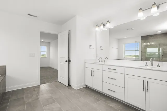 a spacious bathroom with a double vanity sink shower and a mirror