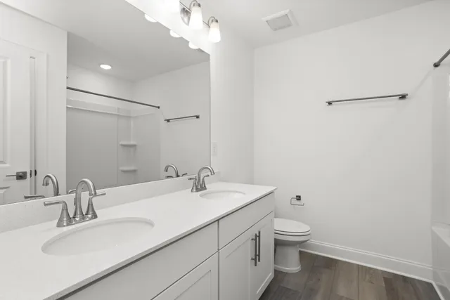 a bathroom with a granite countertop sink a toilet and a mirror