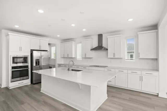 a large kitchen with kitchen island a sink a center island stainless steel appliances and a cabinets