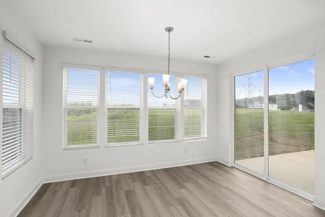 a view of an empty room with glass door and windows