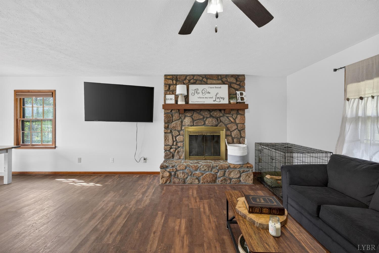 1002 Homeplace Road Rustburg, VA 24588 - Photo 7 of 48 a living room with furniture a flat screen tv and a fireplace