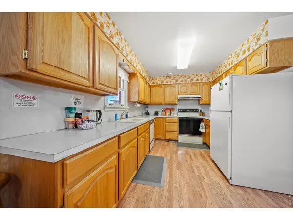 a kitchen with stainless steel appliances granite countertop a sink a stove and a refrigerator