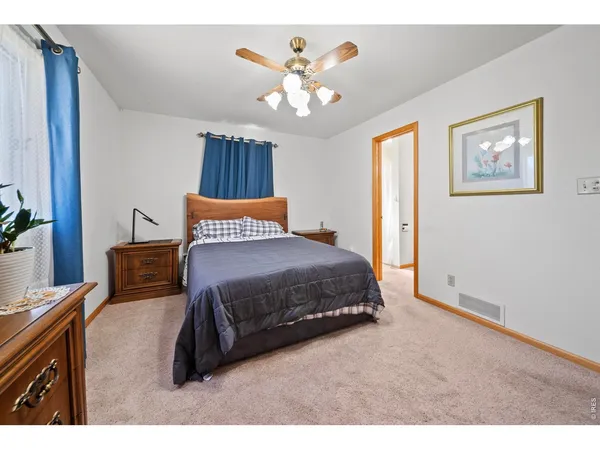 a spacious bedroom with a bed and a chandelier