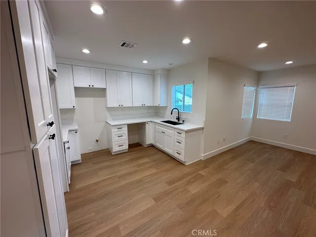 a kitchen with stainless steel appliances a refrigerator sink and wooden floor