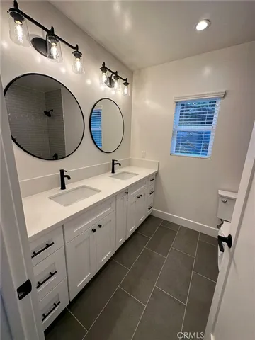 a bathroom with a double vanity sink and a mirror