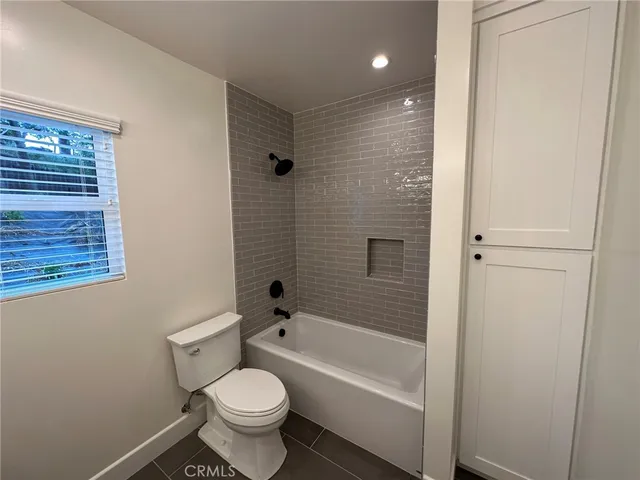 a white toilet sitting next to a bath tub