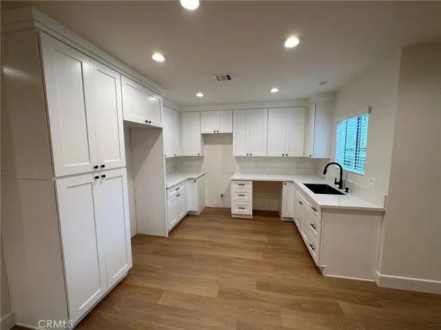 a kitchen with a refrigerator sink and cabinets