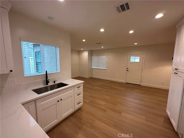 a kitchen with stainless steel appliances granite countertop a sink and a wooden floors