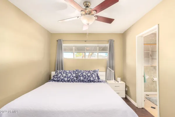 a bedroom with a large bed and a chandelier fan