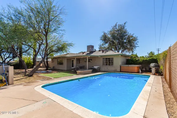 a view of a house with pool and sitting area
