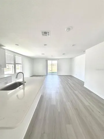 a kitchen with stainless steel appliances a white cabinets and wooden floor