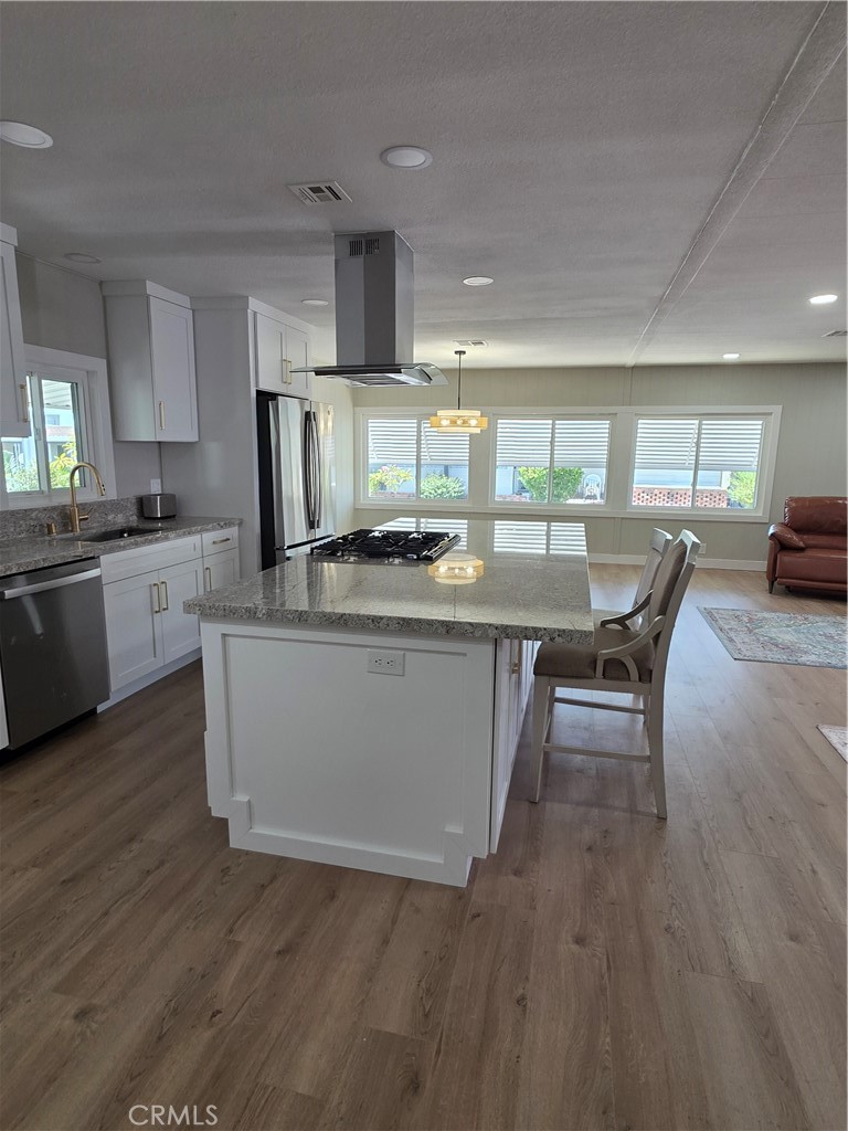 620 Lake Ridge Way, Unit 45 La Habra, CA 90631 - Photo 6 of 21 a kitchen with stainless steel appliances granite countertop wooden floors and view living room