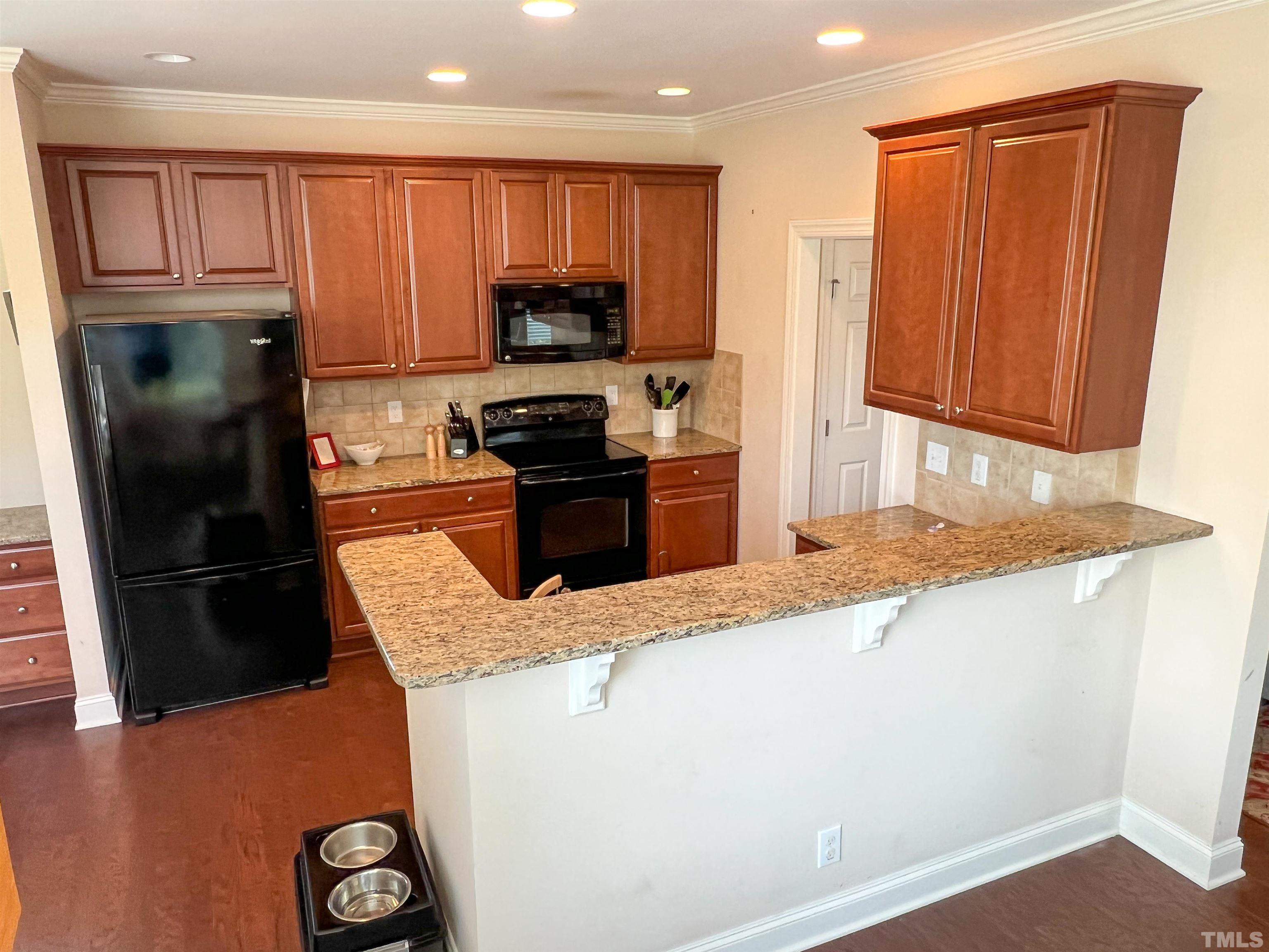 1108 Ileagnes Road Raleigh, NC 27603 - Photo 4 of 30 a kitchen with granite countertop a refrigerator stove and microwave