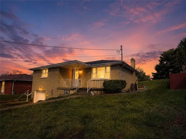 a yellow and red house sitting in middle of a yard