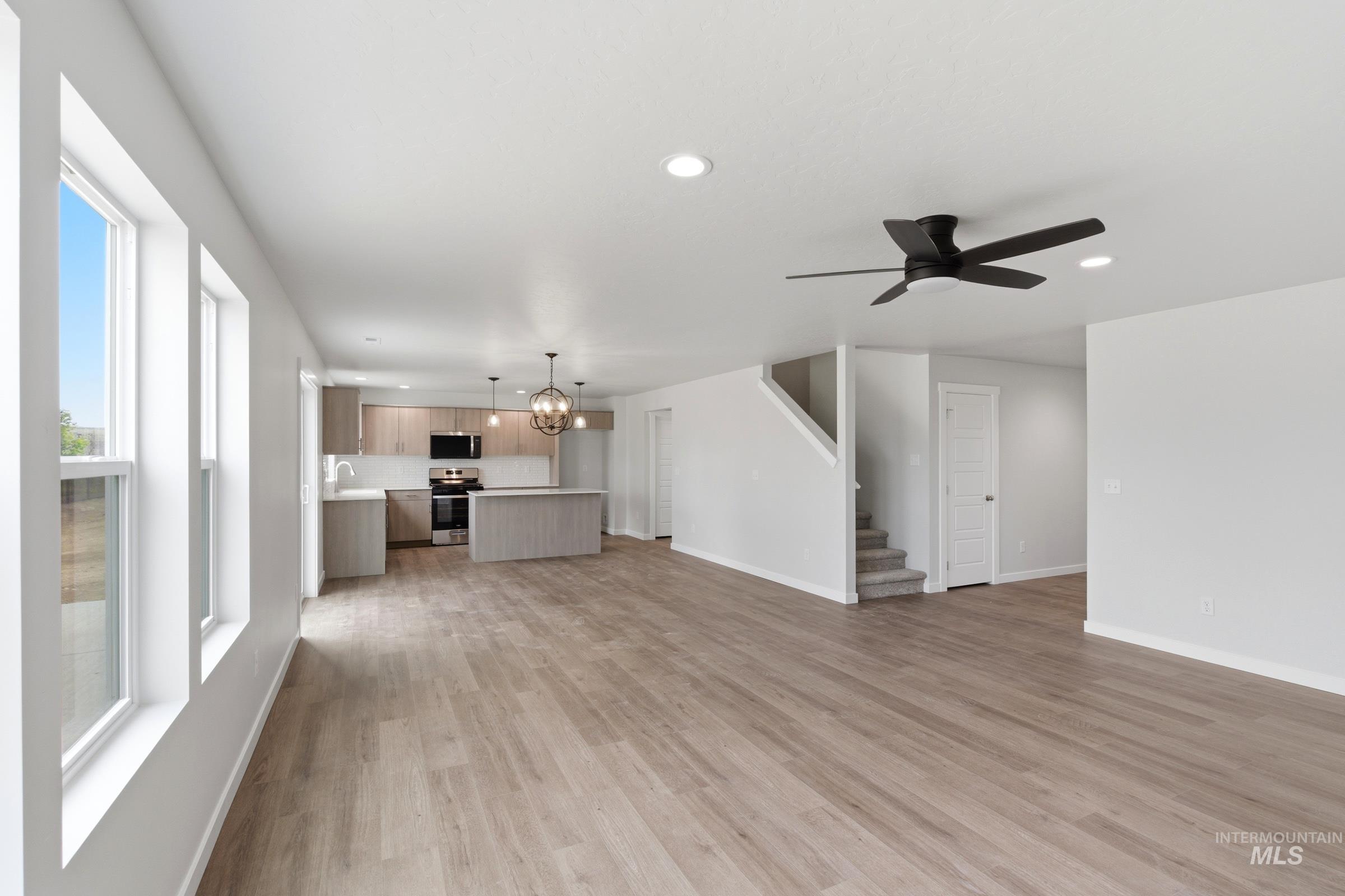 12829 Decatur Street Nampa, ID 83651 - Photo 11 of 33 Open-concept living space featuring wood-finish flooring, a contemporary ceiling fan, recessed lighting, and multiple windows