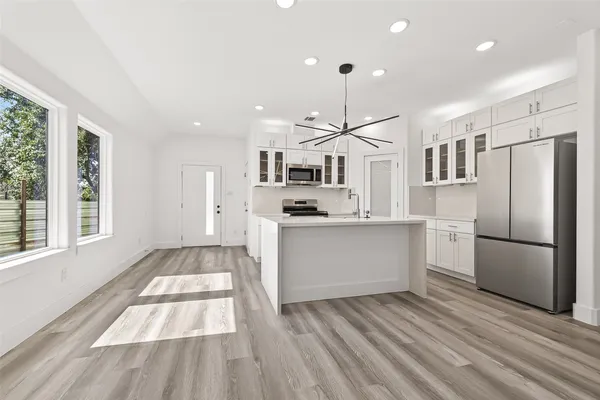 a kitchen with stainless steel appliances a refrigerator sink and cabinets
