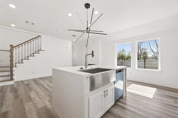 a kitchen with a stove a sink and a chandelier