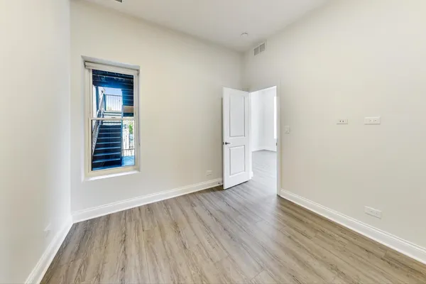 an empty room with wooden floor and closet