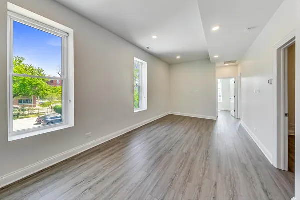 a view of a room with wooden floor and window