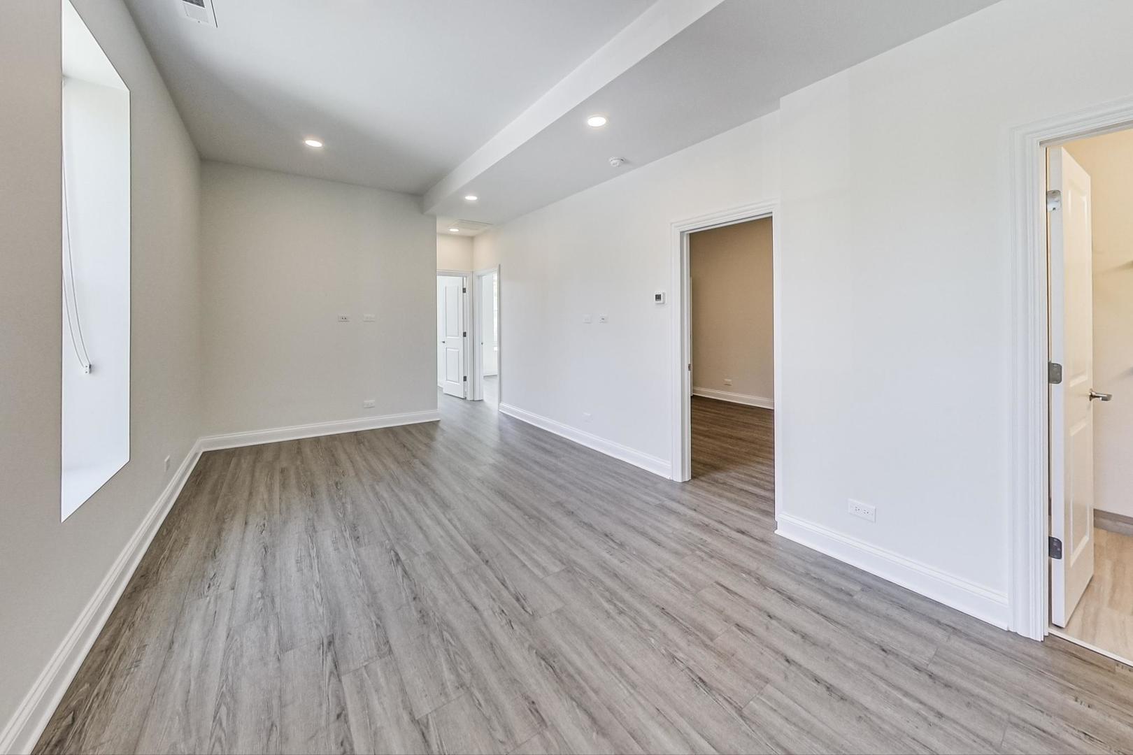 2312 West Ohio Street, Unit 2S Chicago, IL 60612 - Photo 5 of 18 wooden floor in an empty room with a window