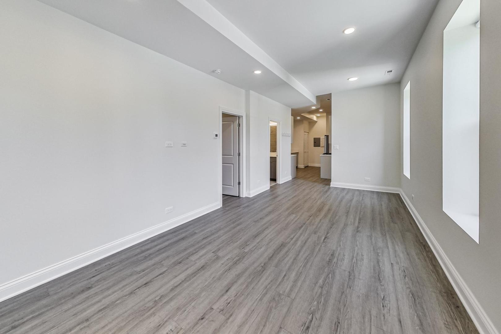 2312 West Ohio Street, Unit 2S Chicago, IL 60612 - Photo 6 of 18 a view of a big room with wooden floor and windows