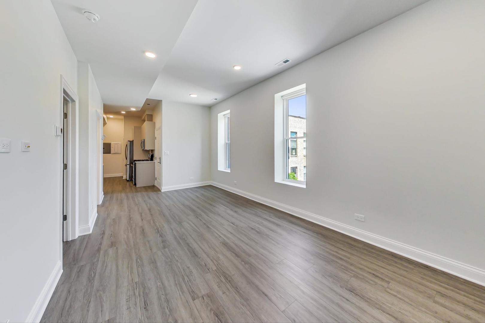 2312 West Ohio Street, Unit 2S Chicago, IL 60612 - Photo 7 of 18 wooden floor in an empty room with a window