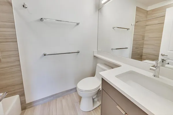 a bathroom with a sink a toilet and shower
