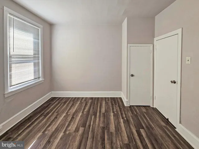 a view of a room with wooden floor and window