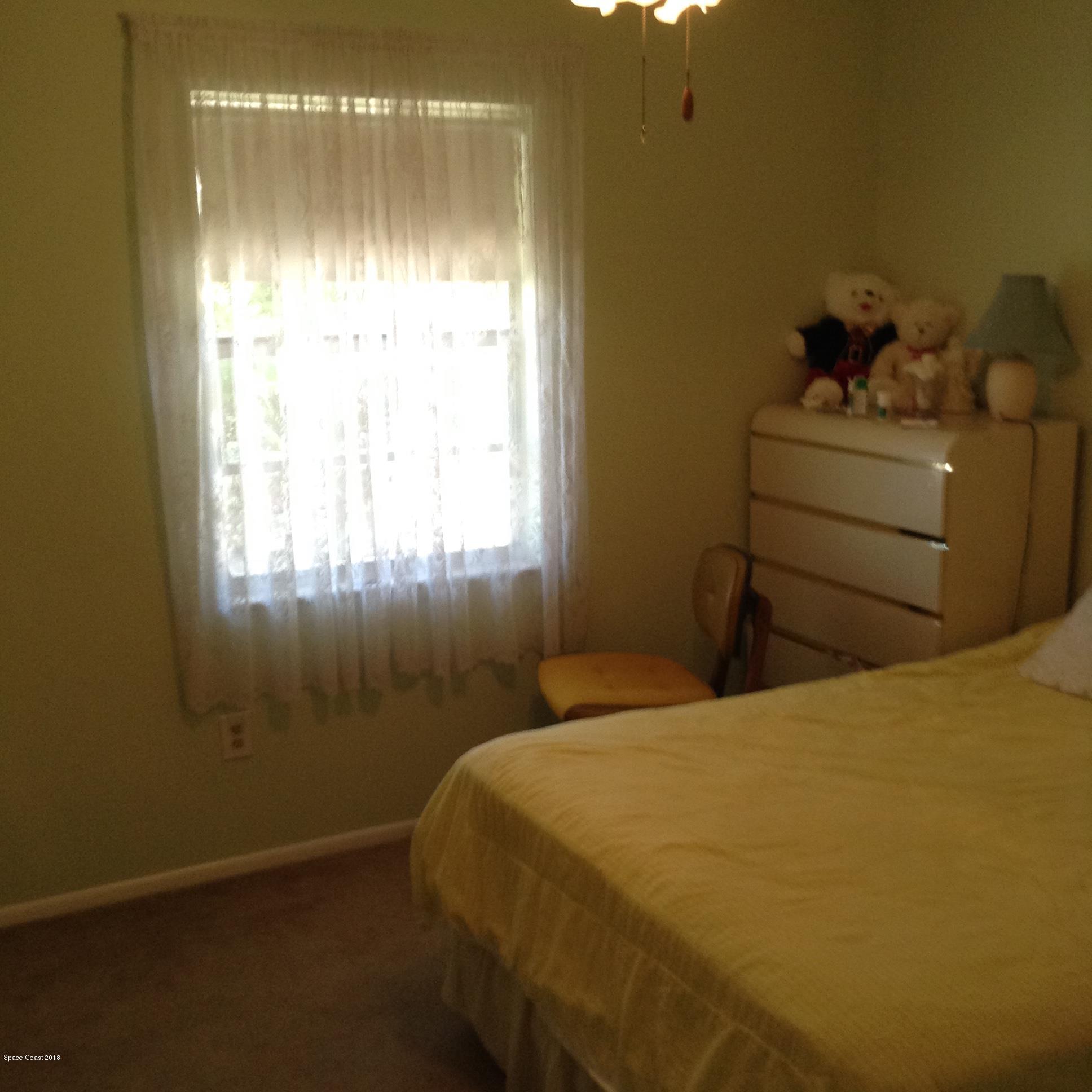 501 Croton Road Melbourne, FL 32935 - Photo 8 of 20 a bedroom with a bed and a window