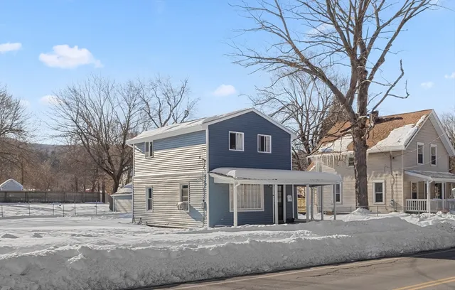 a front view of residential houses with yard and trees