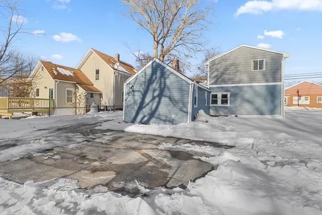 a view of a dry yard covered with snow in the background