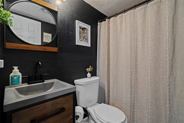 a bathroom with a sink a toilet and a mirror