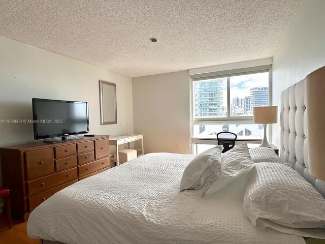 a bedroom with a bed and a flat screen tv