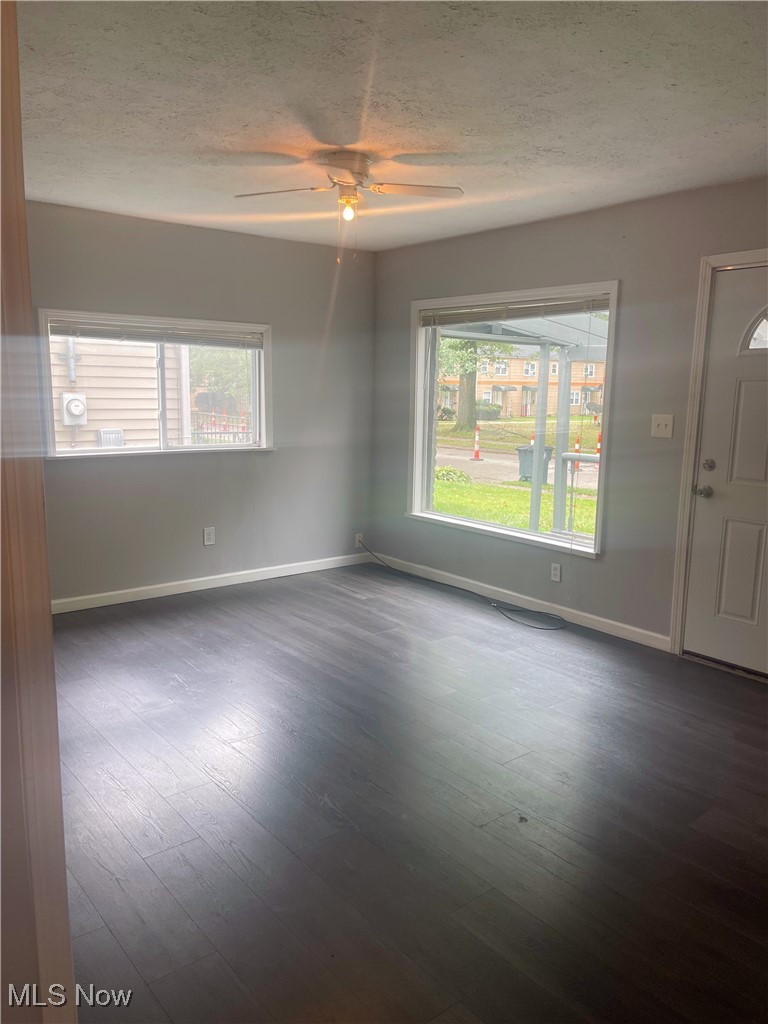 1053 Inman Street Akron, OH 44306 - Photo 2 of 17 Empty room with a textured ceiling, ceiling fan, and dark hardwood / wood-style flooring