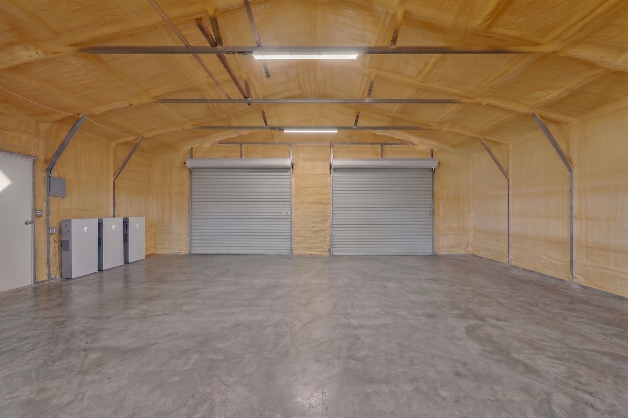 664 Garrett Road Yoakum, TX 77995 - Photo 15 of 39 Spacious interior featuring a concrete floor, two roll-up doors, and insulated walls and ceiling