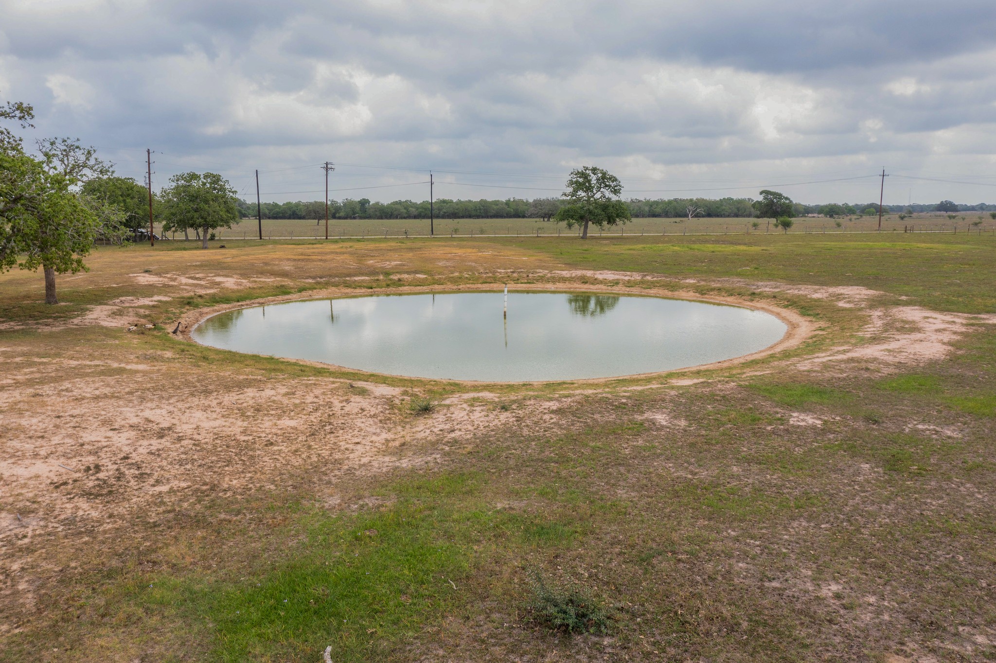 664 Garrett Road Yoakum, TX 77995 - Photo 19 of 39 Circular pond surrounded by natural terrain and scattered trees