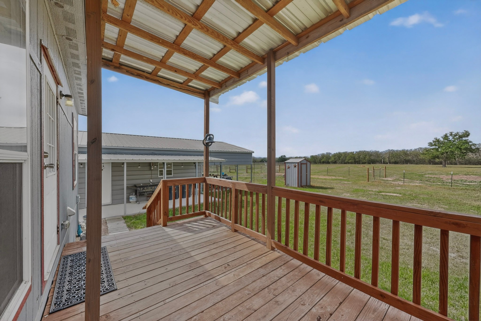 664 Garrett Road Yoakum, TX 77995 - Photo 21 of 39 Expansive wood deck with a durable metal roof, offering covered outdoor space