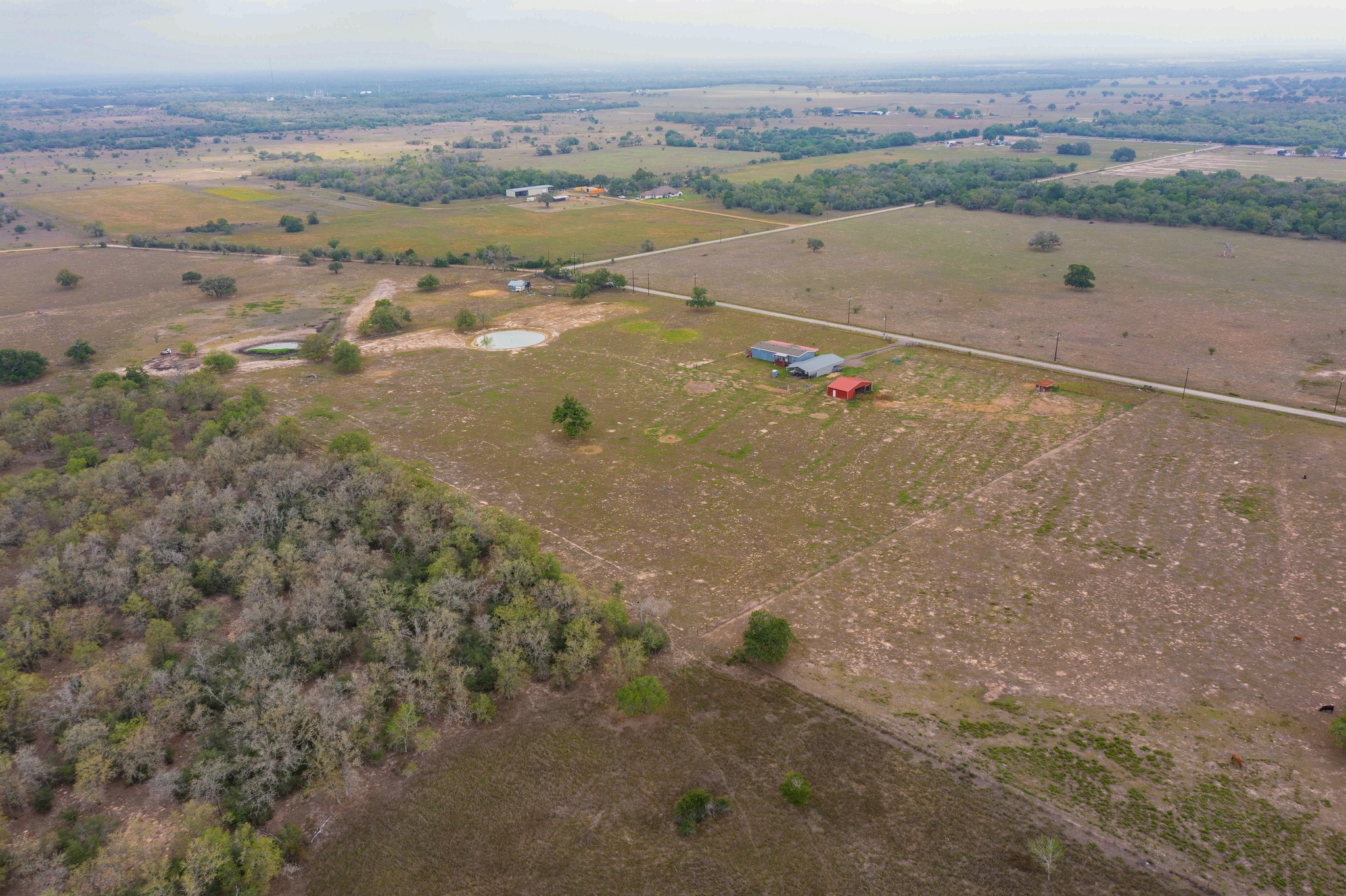 664 Garrett Road Yoakum, TX 77995 - Photo 27 of 39 Expansive rural property featuring multiple outbuildings, two ponds, and a mix of cleared land and wooded areas