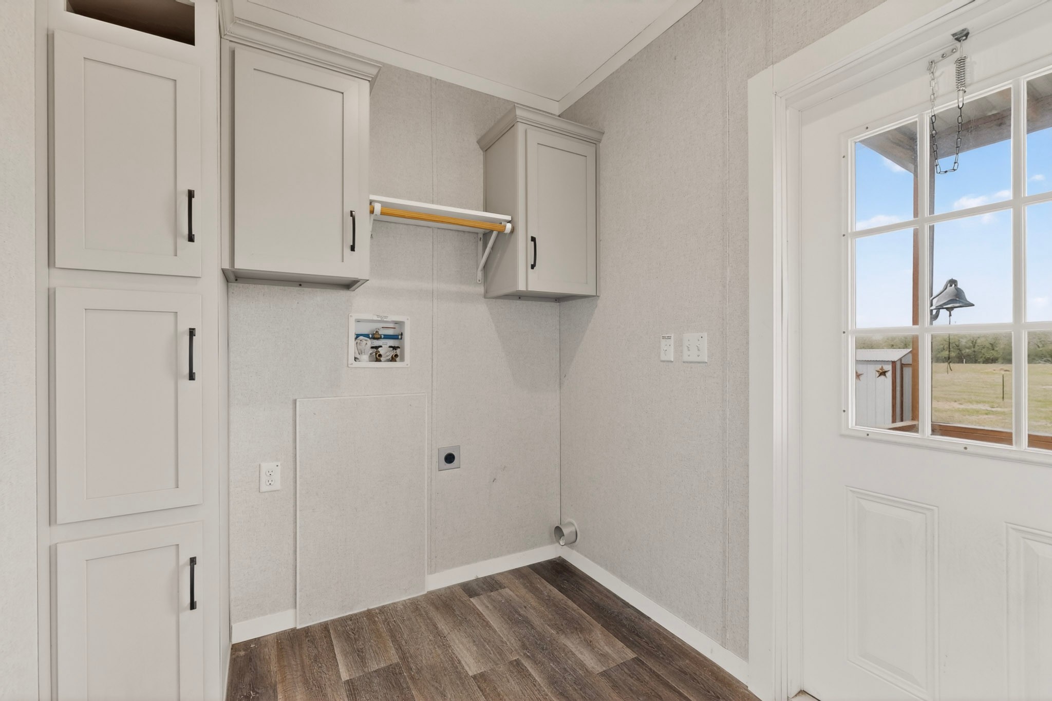 664 Garrett Road Yoakum, TX 77995 - Photo 37 of 39 Dedicated utility space featuring light-toned cabinetry with dark hardware