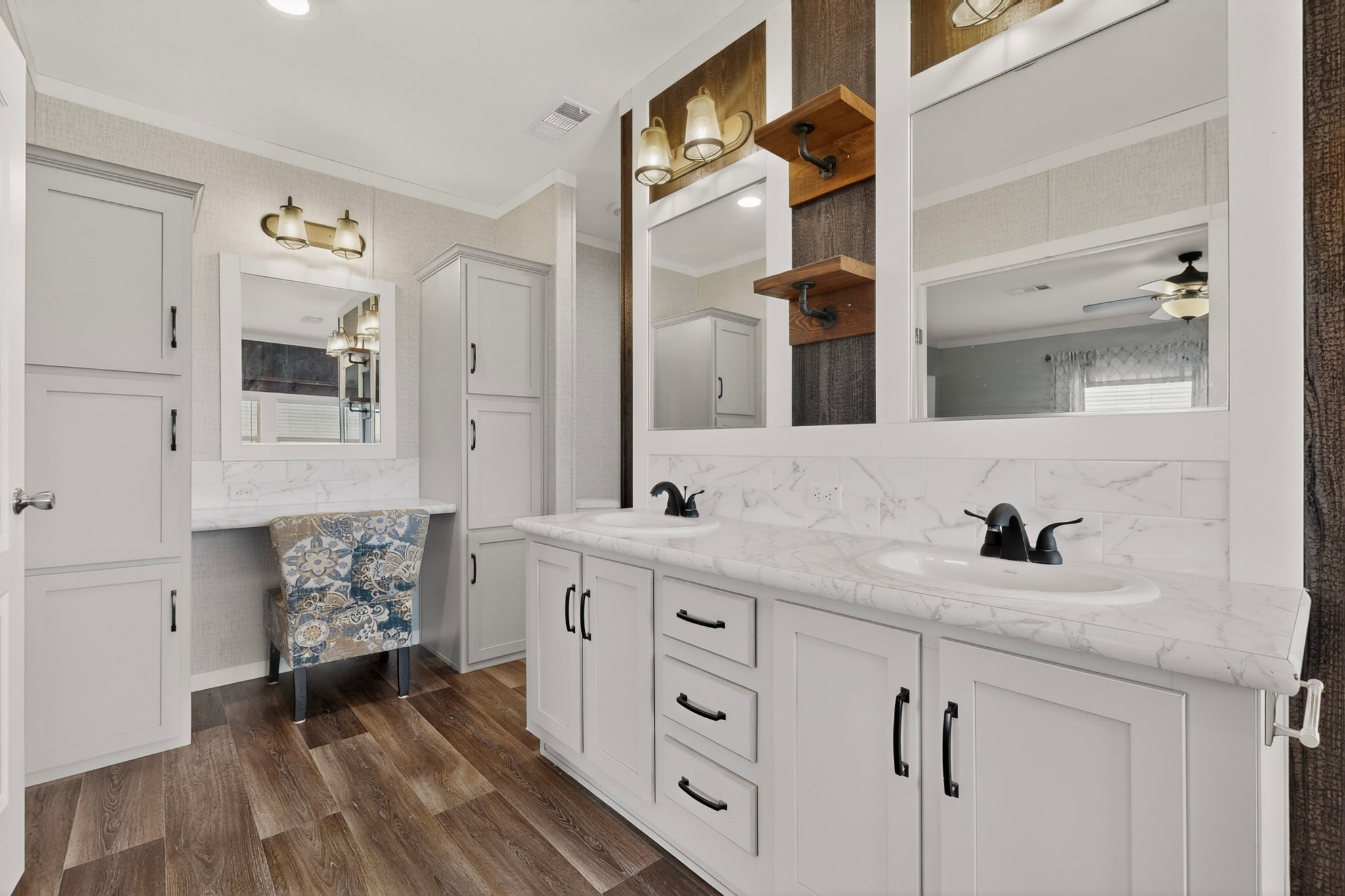 664 Garrett Road Yoakum, TX 77995 - Photo 8 of 39 Dual basin vanity with white cabinetry, integrated sinks, black fixtures, and Beauflor luxury vinyl plank flooring