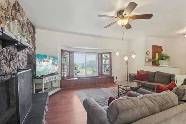 a living room with furniture ceiling fan and a rug